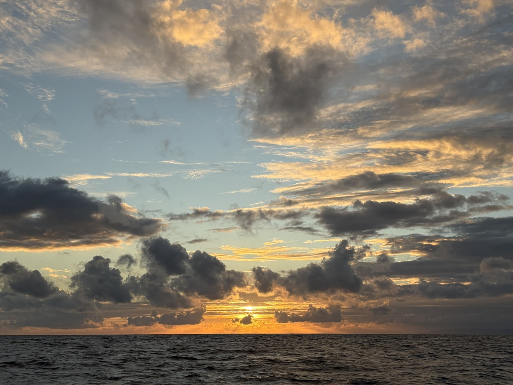 Craig Spiesman image of a cloudy ocean horizon with orange and blue tones in the sky
