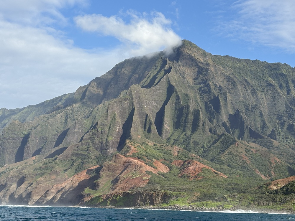 Craig Spiesman image showing towering green cliffs along a rocky shoreline
